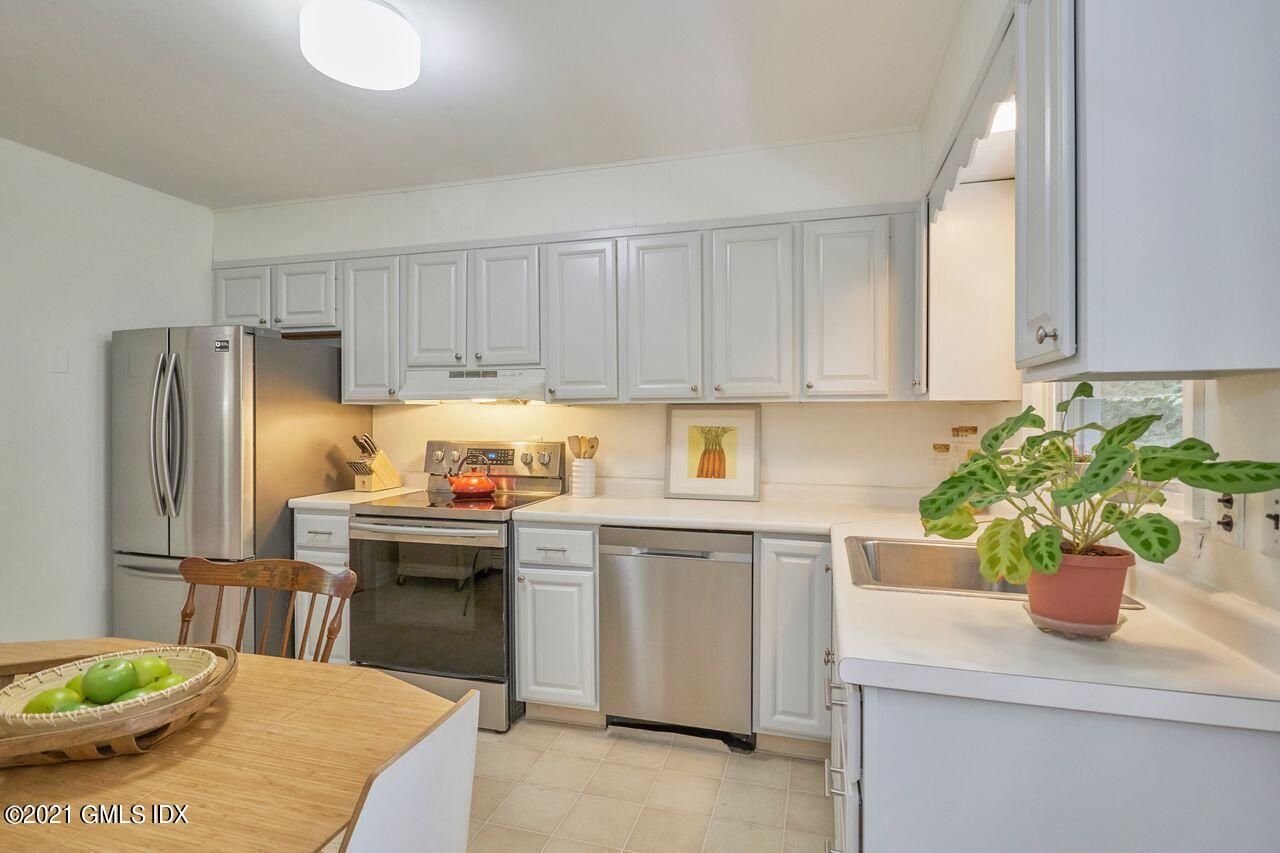 16 Cat Rock Road Cos Cob, CT 06807 - Photo 9 of 26 a kitchen with stainless steel appliances kitchen island granite countertop a refrigerator a stove a sink dishwasher and white cabinets