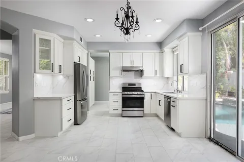 a kitchen with stainless steel appliances a refrigerator sink and stove