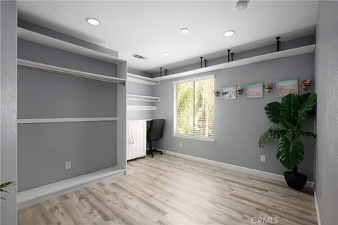 a view of empty room with wooden floor and potted plant