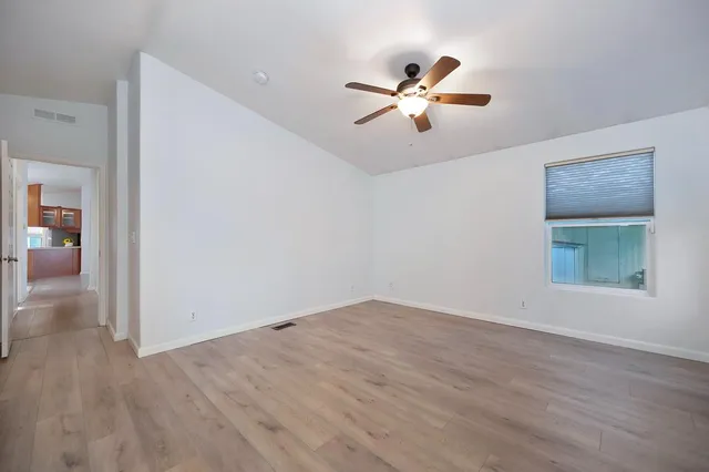 a view of empty room with wooden floor