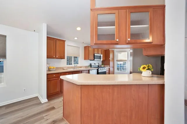 a kitchen with granite countertop a sink a stove and cabinets
