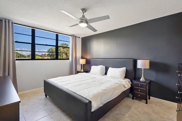 a large bedroom with a bed and a large window