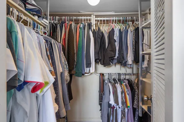 a view of walk in closet with clothes