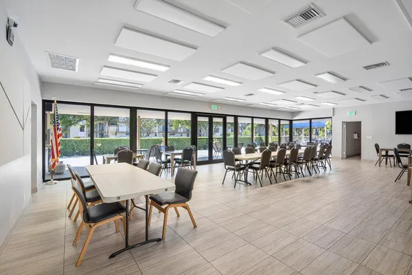 a dining room with furniture water view and a floor to ceiling window