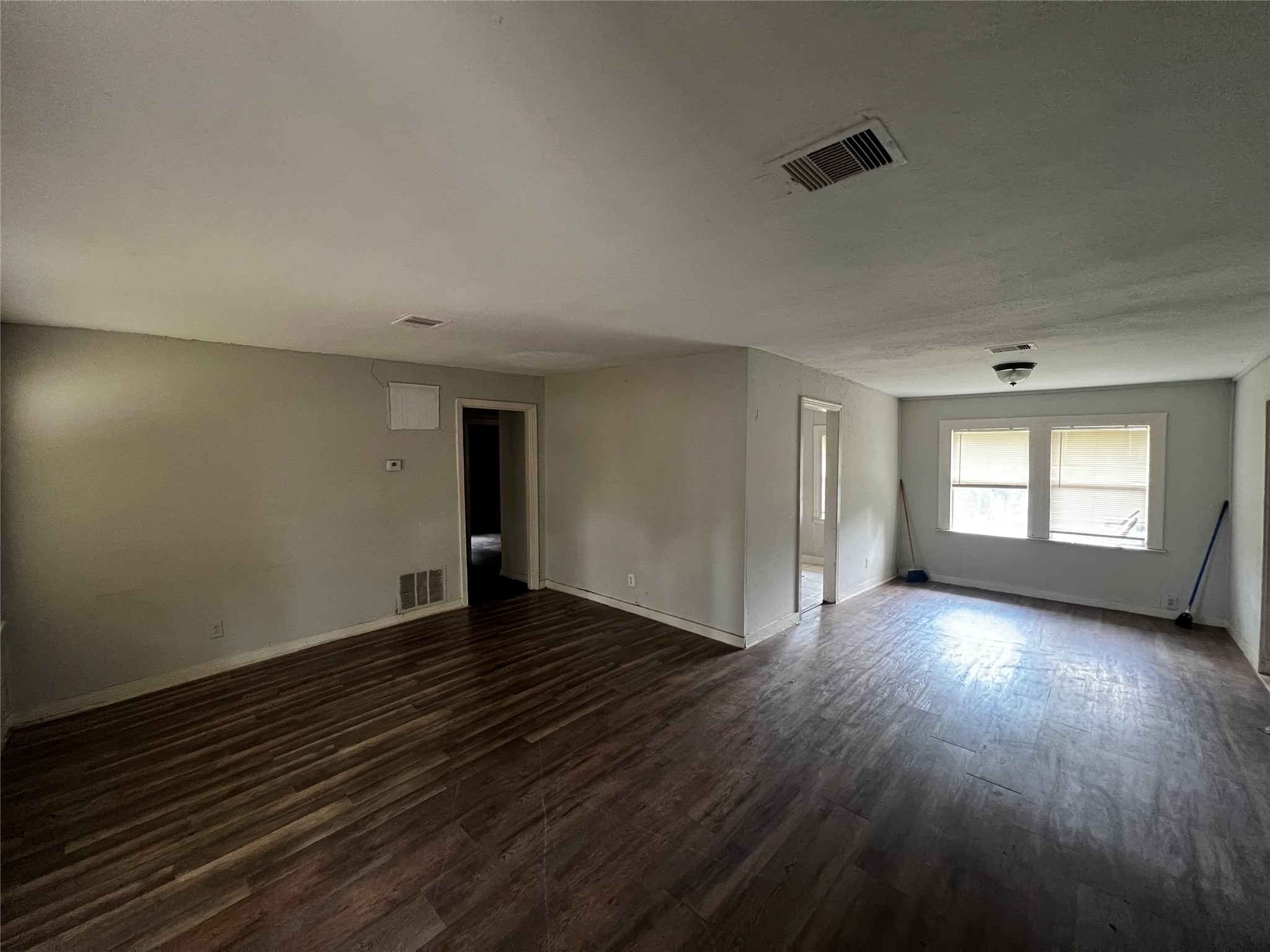 5926 Southtown Street Houston, TX 77033 - Photo 2 of 7 an empty room with wooden floor and windows