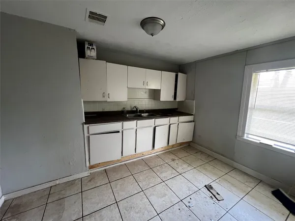 a kitchen with a sink a stove and cabinets