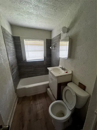 a bathroom with a toilet a sink and bathtub