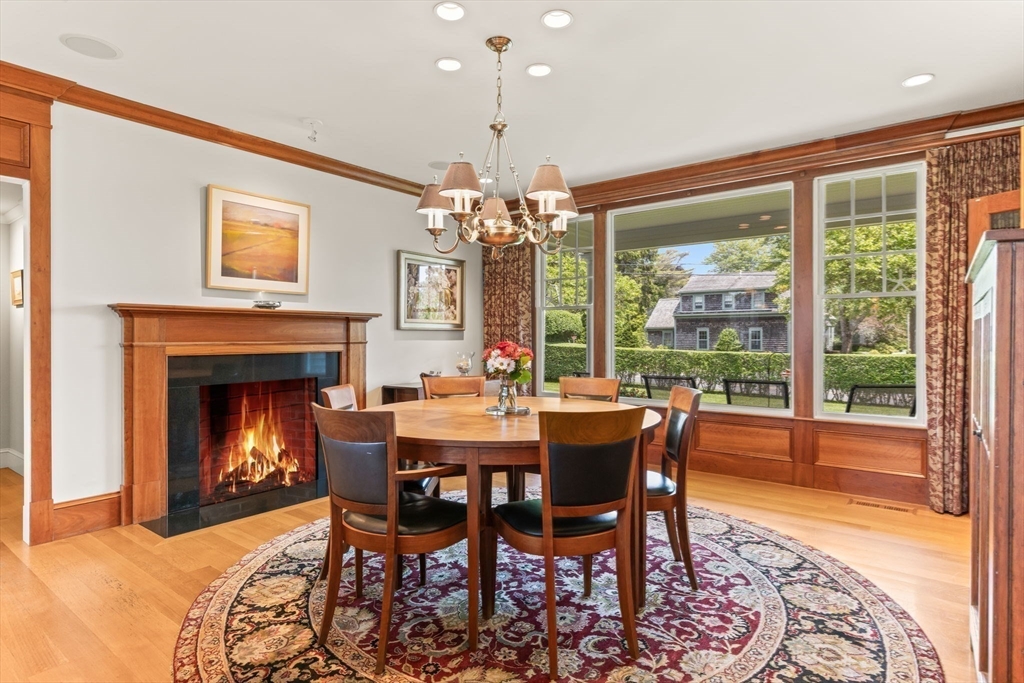 785 Old Harbor Road Chatham, MA 02650 - Photo 5 of 40 a view of a dining room with furniture wooden floor a chandelier and a fireplace