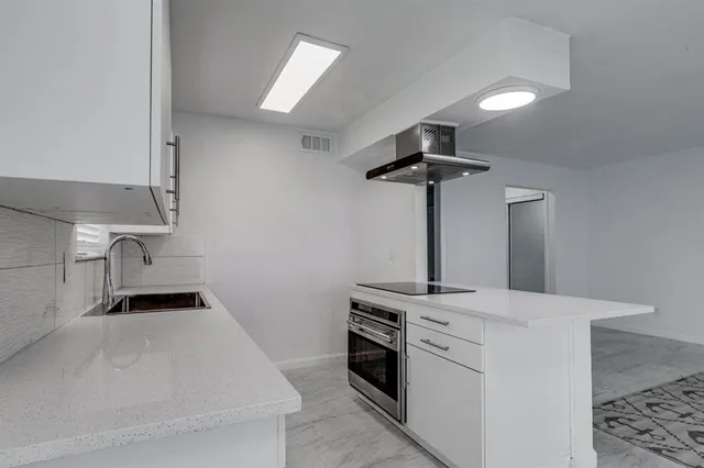 a kitchen with a white cabinets and window
