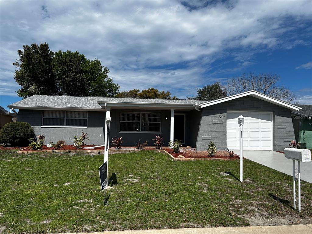7207 Nova Scotia Drive Port Richey, FL 34668 - Photo 1 of 1 a front view of a house with a yard
