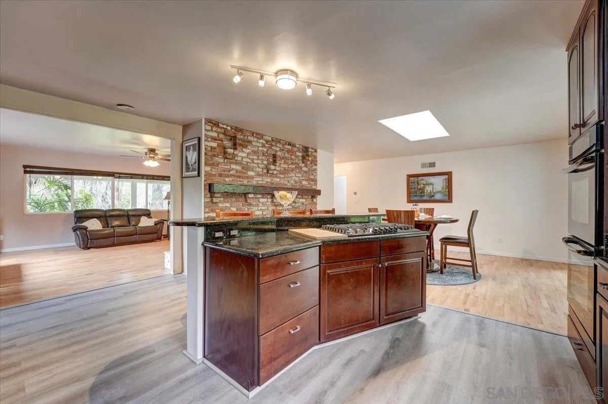 4561 Conrad Drive La Mesa, CA 91941 - Photo 11 of 59 a kitchen with stainless steel appliances granite countertop a stove and a wooden floors