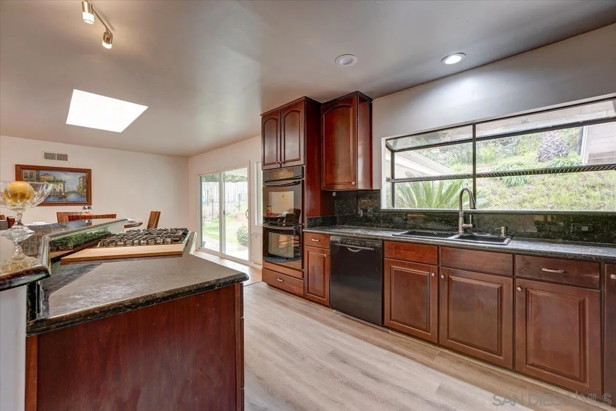 4561 Conrad Drive La Mesa, CA 91941 - Photo 14 of 59 a kitchen with granite countertop a sink stove and cabinets