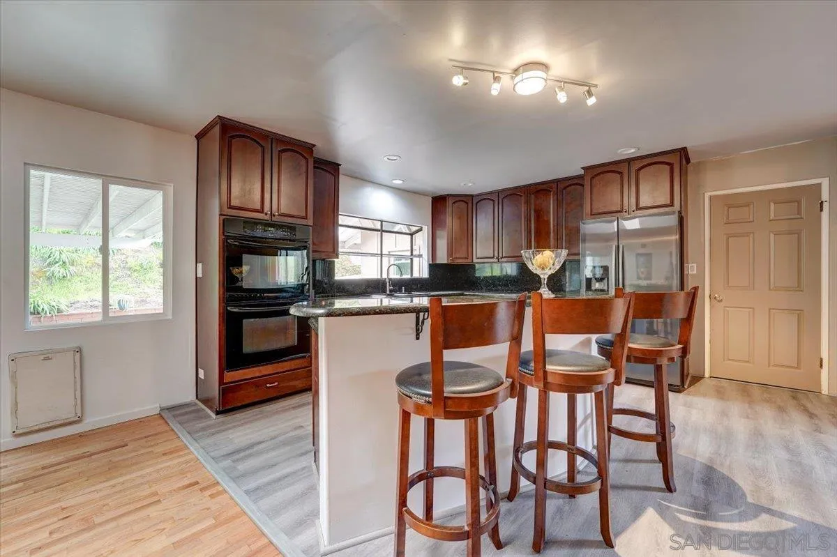 4561 Conrad Drive La Mesa, CA 91941 - Photo 19 of 59 a dining room with granite countertop wooden floor and stainless steel appliances