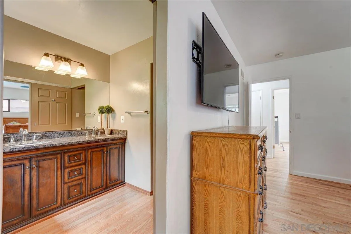 4561 Conrad Drive La Mesa, CA 91941 - Photo 22 of 59 a bathroom with a granite countertop sink a mirror and a shower