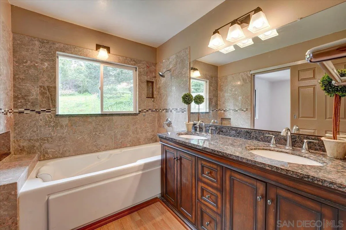 4561 Conrad Drive La Mesa, CA 91941 - Photo 23 of 59 a bathroom with a granite countertop tub sink and mirror