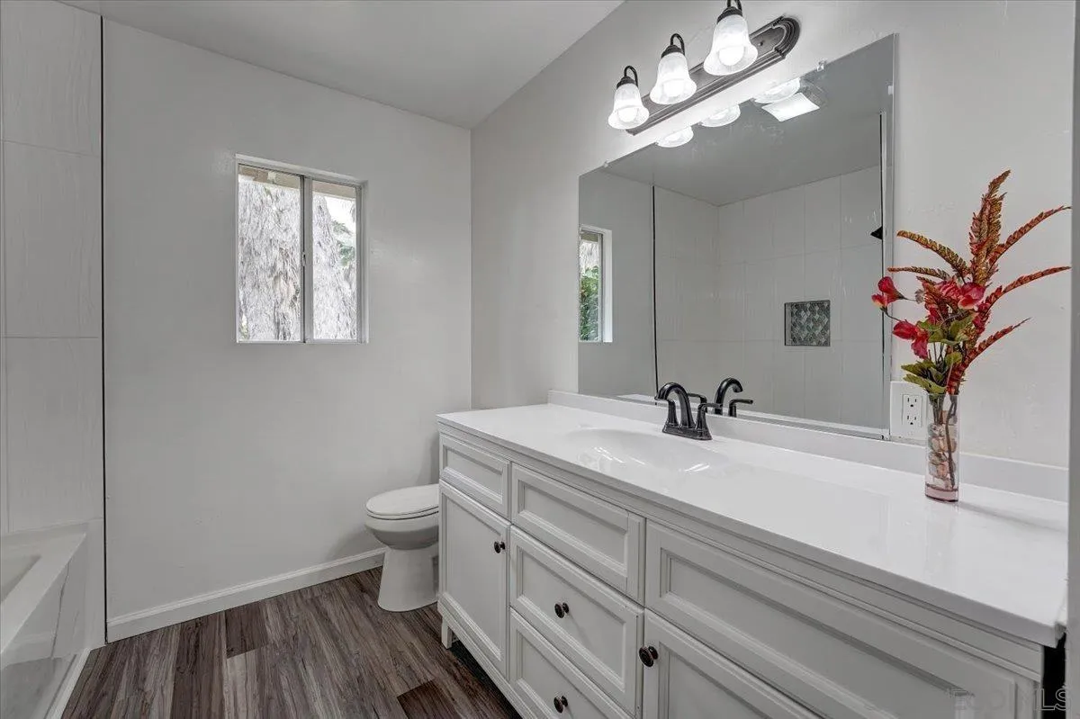 4561 Conrad Drive La Mesa, CA 91941 - Photo 26 of 59 a bathroom with a sink a toilet and a mirror