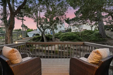 a balcony with wooden floor and outdoor seating