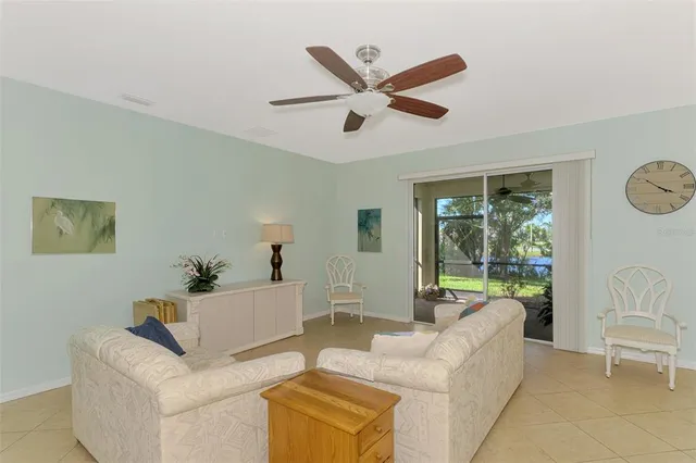 a living room with couches and furniture with a large window