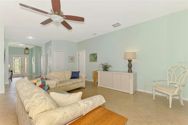 a living room with furniture and a ceiling fan