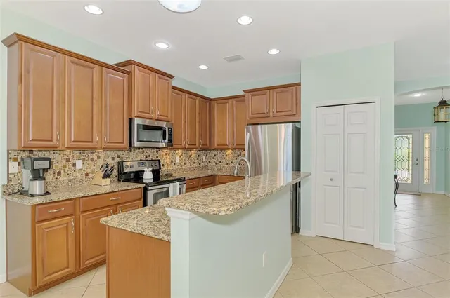 a kitchen with stainless steel appliances granite countertop a refrigerator stove top oven a sink and dishwasher