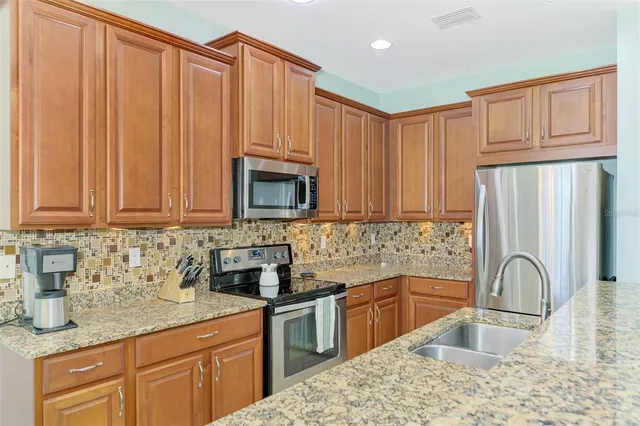 a kitchen with stainless steel appliances granite countertop a sink stove and refrigerator