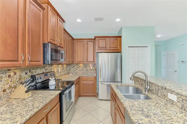 a kitchen with stainless steel appliances granite countertop a sink and refrigerator