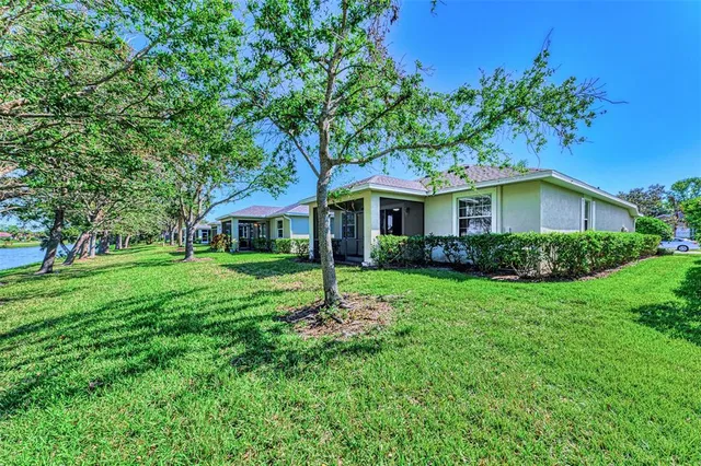 a view of a house with a tree and a yard