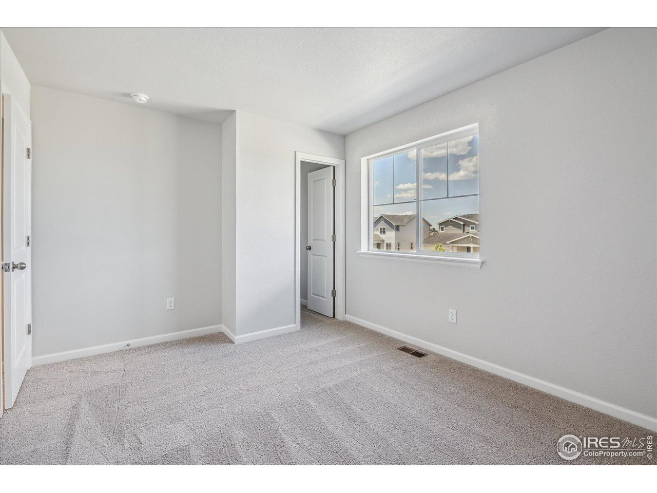 882 Mesic Lane Windsor, CO 80550 - Photo 15 of 26 an empty room with windows