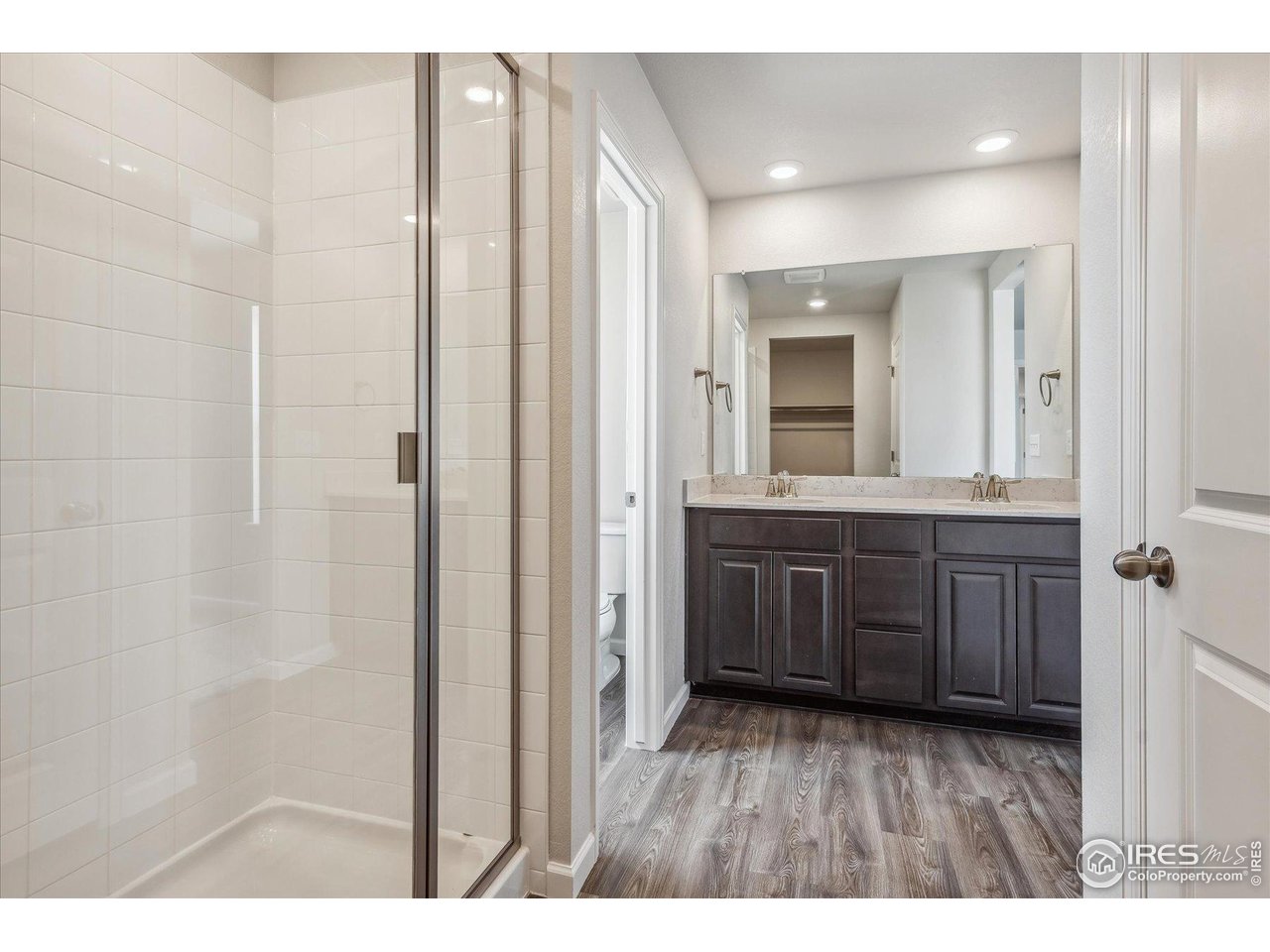 882 Mesic Lane Windsor, CO 80550 - Photo 23 of 26 a bathroom with a vanity and a mirror