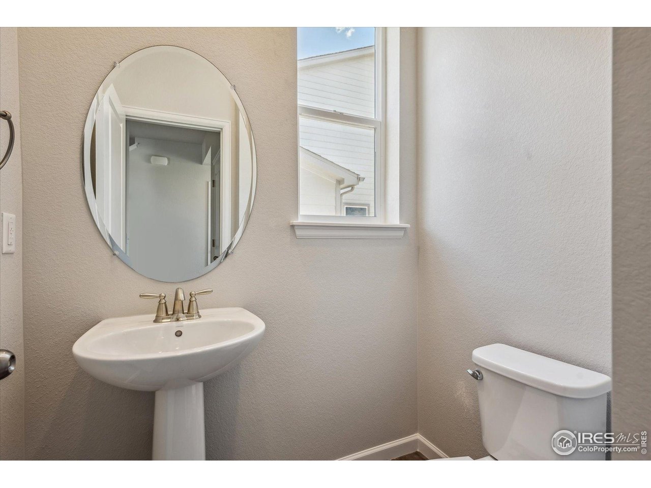 882 Mesic Lane Windsor, CO 80550 - Photo 5 of 26 a bathroom with a toilet a sink and mirror