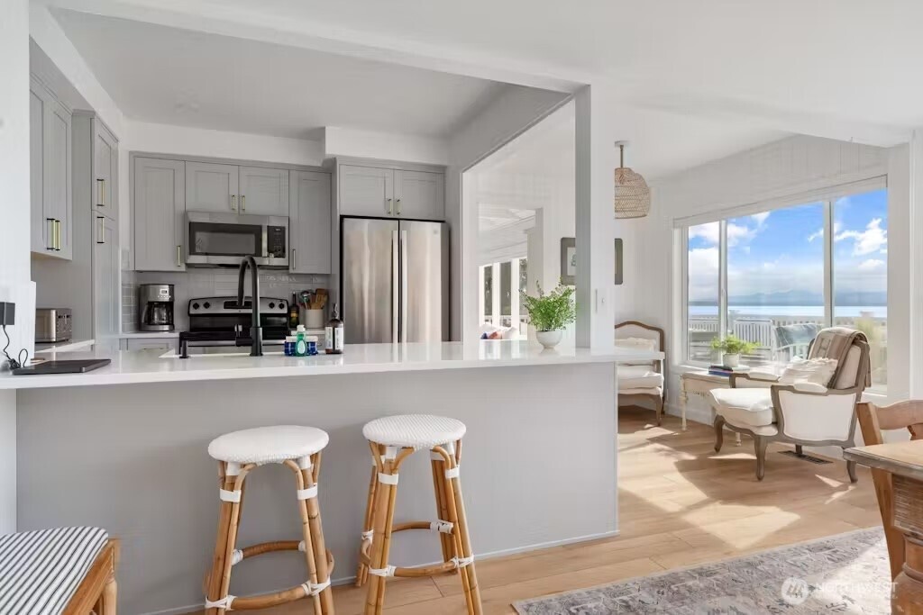 6192 Kohlwes Road Clinton, WA 98236 - Photo 5 of 12 a living room with furniture a large window and stainless steel appliances