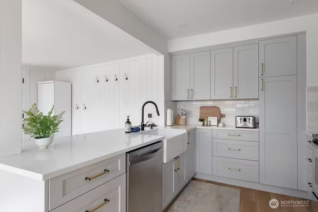 6192 Kohlwes Road Clinton, WA 98236 - Photo 6 of 12 a kitchen with white cabinets and a potted plant