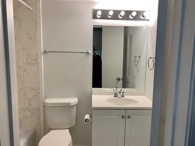 a white toilet and tub sitting next to a bathroom sink