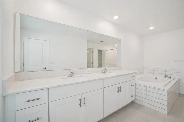 a spacious bathroom with a double vanity sink and mirror
