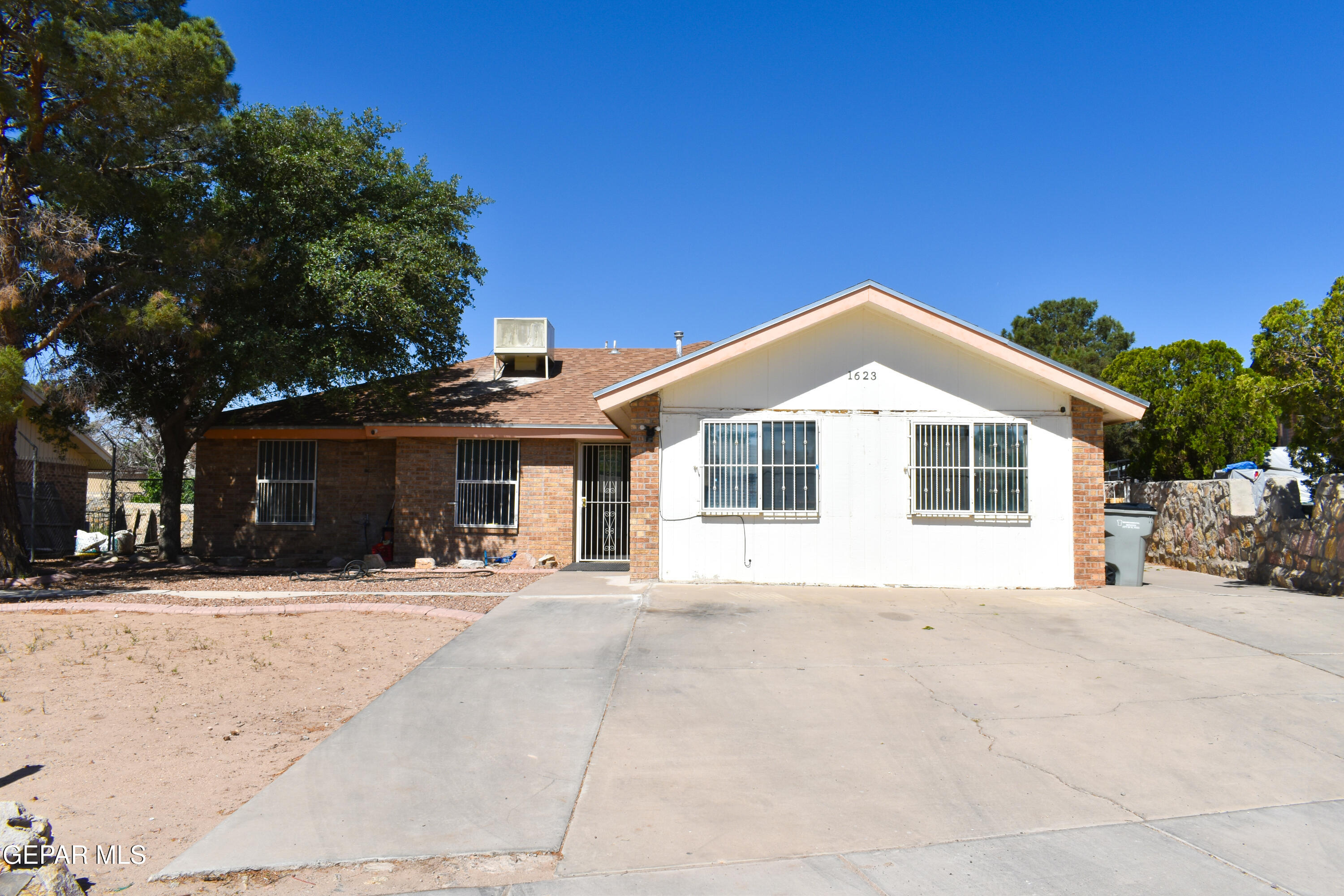 a view of a white house with a large tree