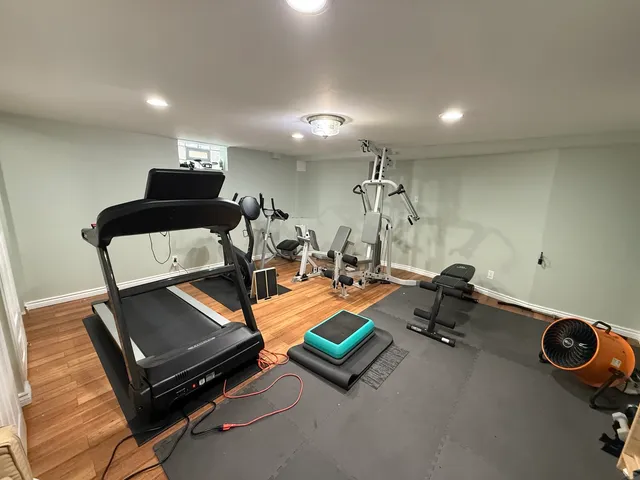 a room with gym equipment and a wooden floor