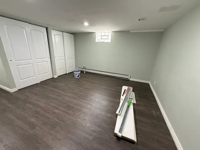 an empty room with wooden floor and white walls