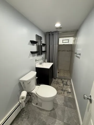 a bathroom with a toilet a sink and mirror