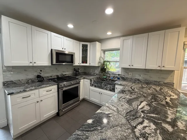 a kitchen with sink a microwave and cabinets