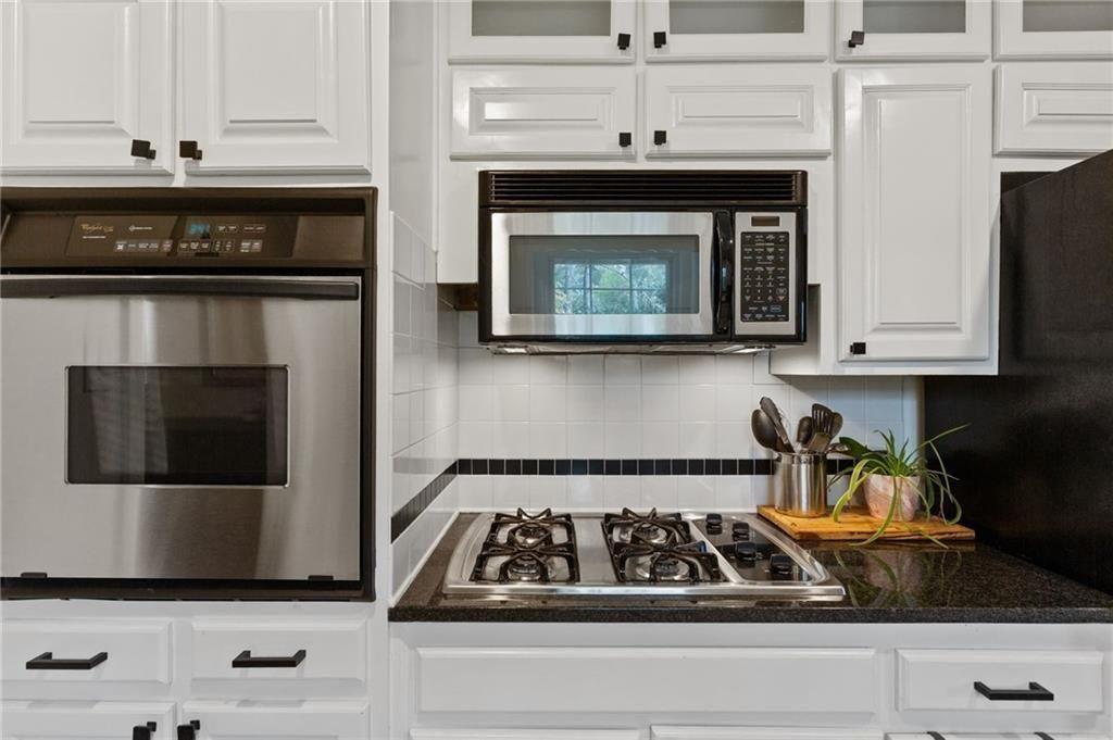 2624 Peeler Road Atlanta, GA 30360 - Photo 14 of 46 a kitchen with white cabinets and black appliances