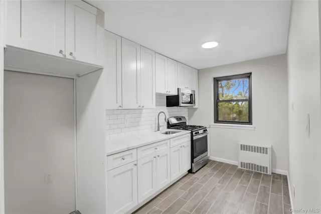 a kitchen with a sink cabinets and wooden floor