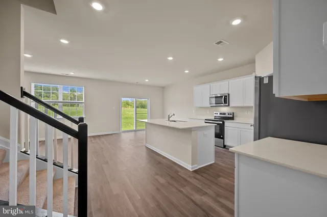 a kitchen with white cabinets and appliances