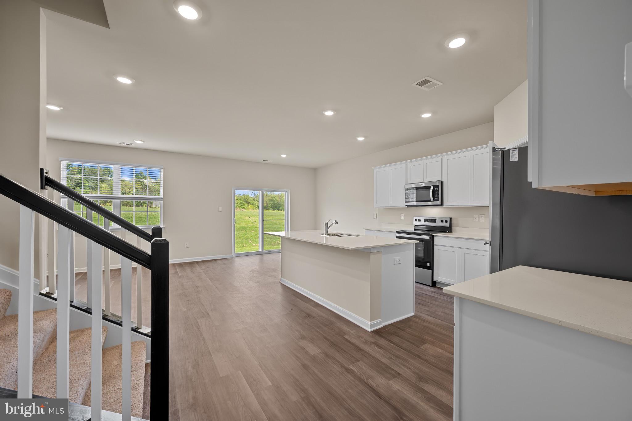 547 Atkinson Street Charles Town, WV 25414 - Photo 5 of 31 a kitchen with white cabinets and appliances