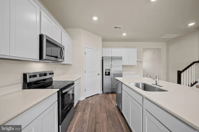 a kitchen with stainless steel appliances a stove sink microwave and cabinets