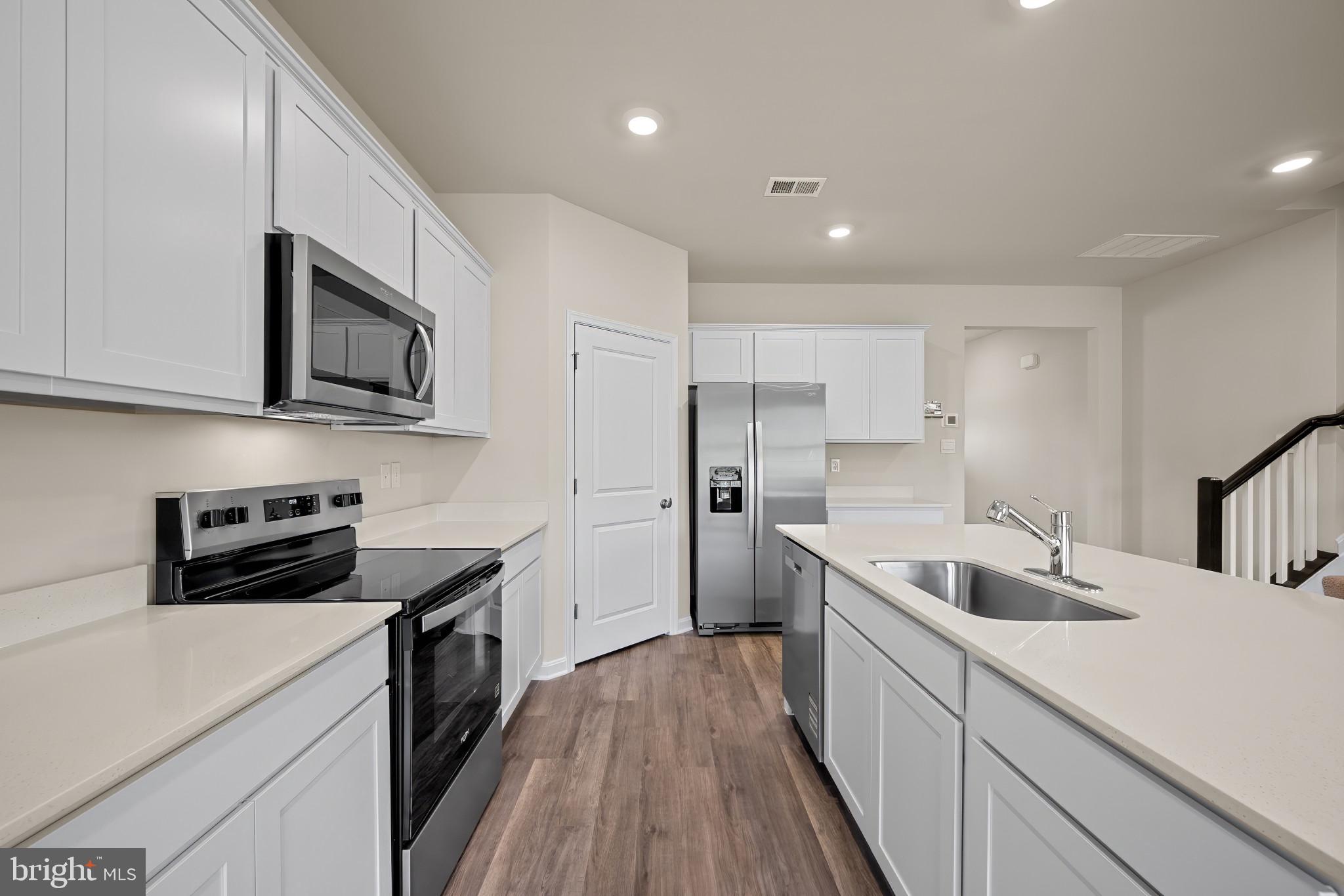 547 Atkinson Street Charles Town, WV 25414 - Photo 8 of 31 a kitchen with stainless steel appliances a stove sink microwave and cabinets