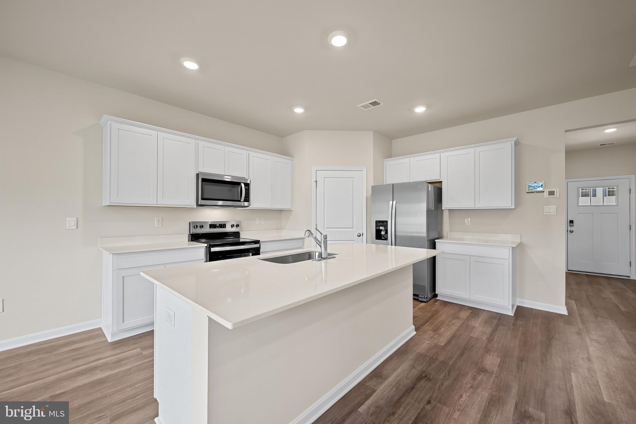 547 Atkinson Street Charles Town, WV 25414 - Photo 9 of 31 a kitchen with a sink a counter top space stainless steel appliances and cabinets