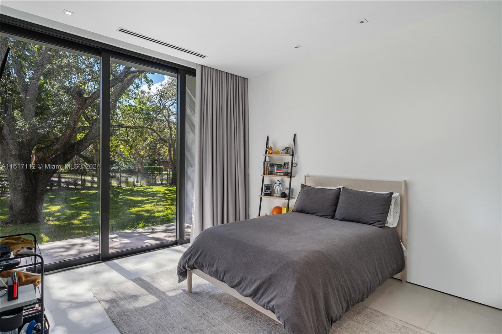 7825 Southwest 128th Street Pinecrest, FL 33156 - Photo 20 of 40 a bedroom with a large bed and a large window