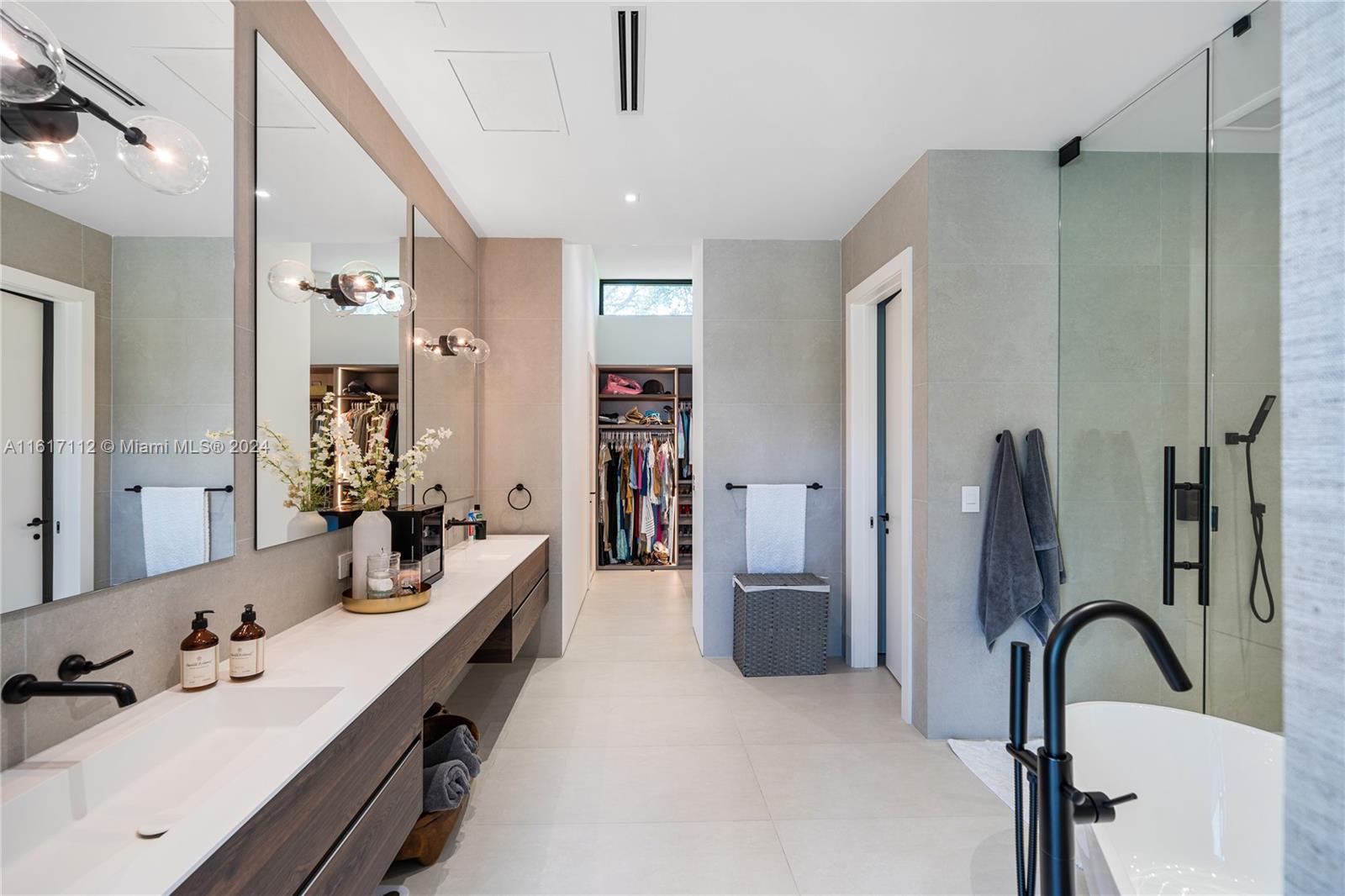 7825 Southwest 128th Street Pinecrest, FL 33156 - Photo 26 of 40 a en suite spacious bathroom with double vanity sinks a large mirror and shower