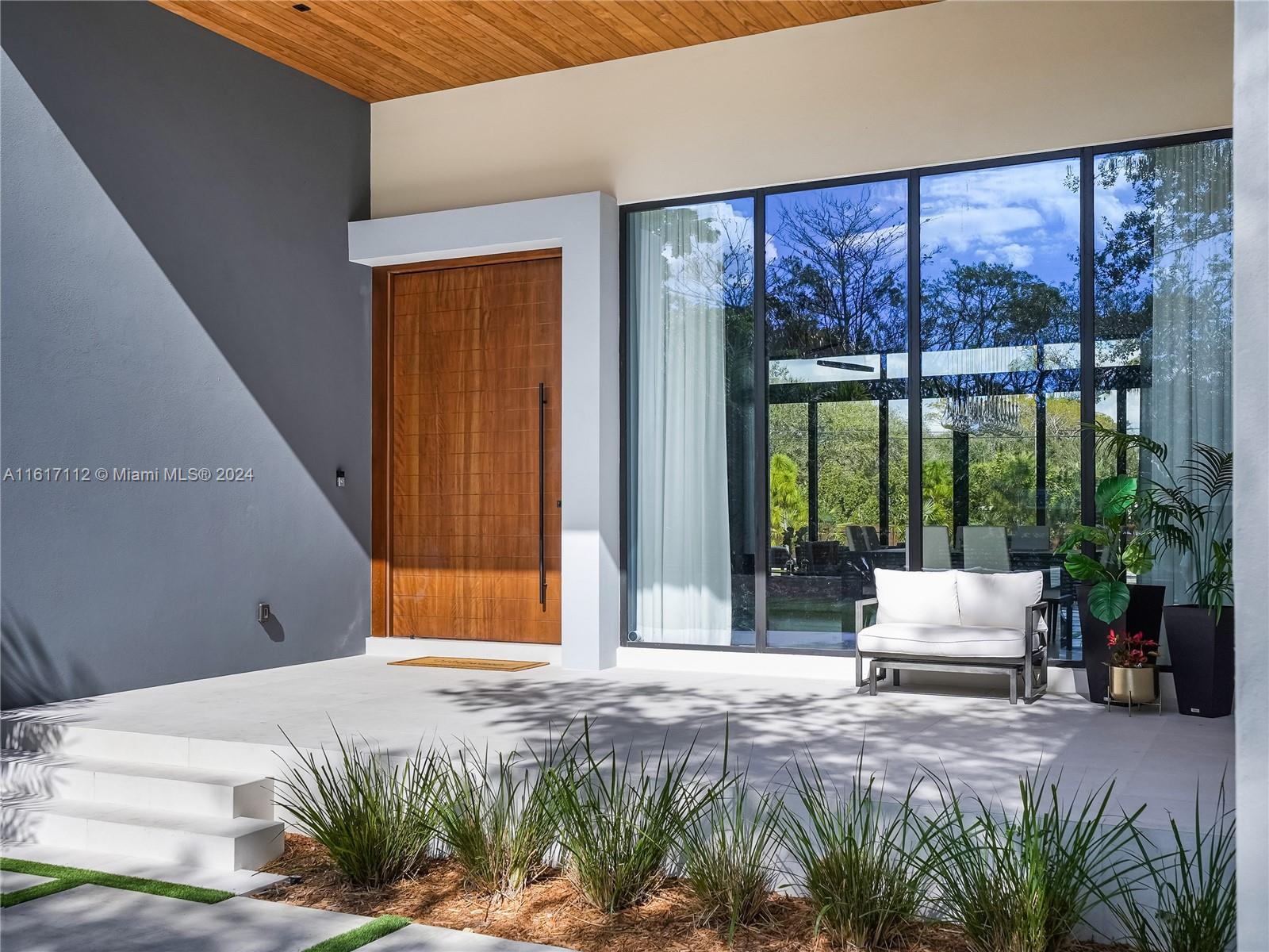 7825 Southwest 128th Street Pinecrest, FL 33156 - Photo 3 of 40 a house with wooden floor and garden