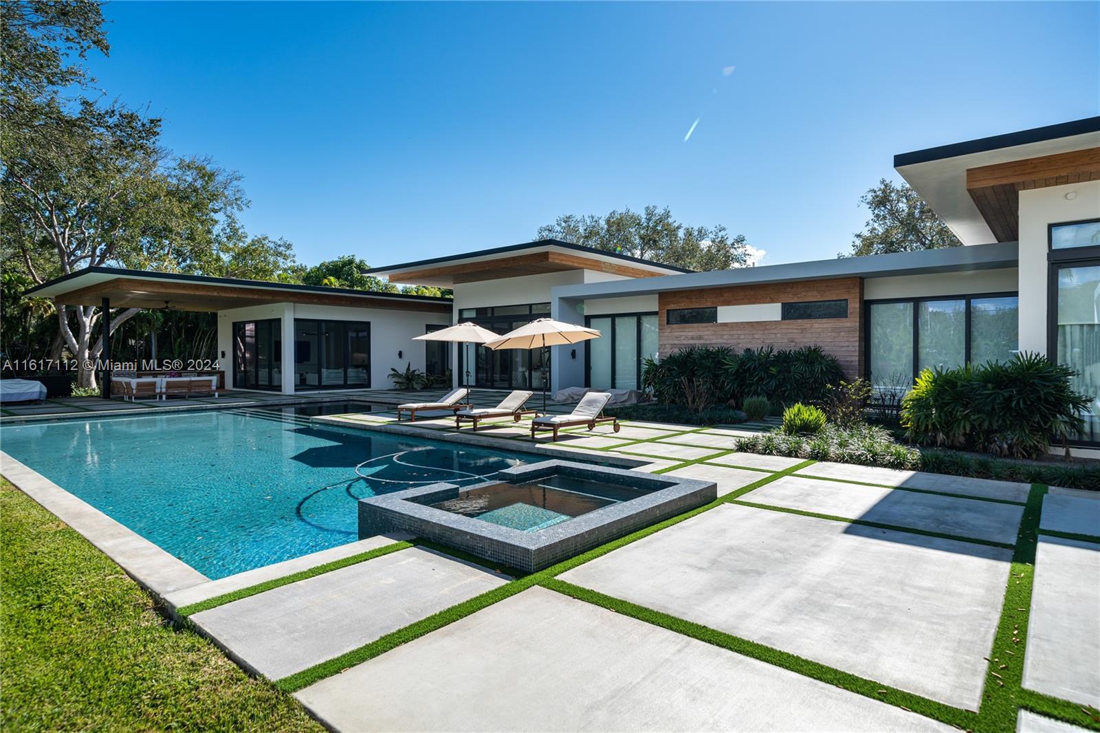 7825 Southwest 128th Street Pinecrest, FL 33156 - Photo 34 of 40 a view of a house with backyard sitting area and swimming pool